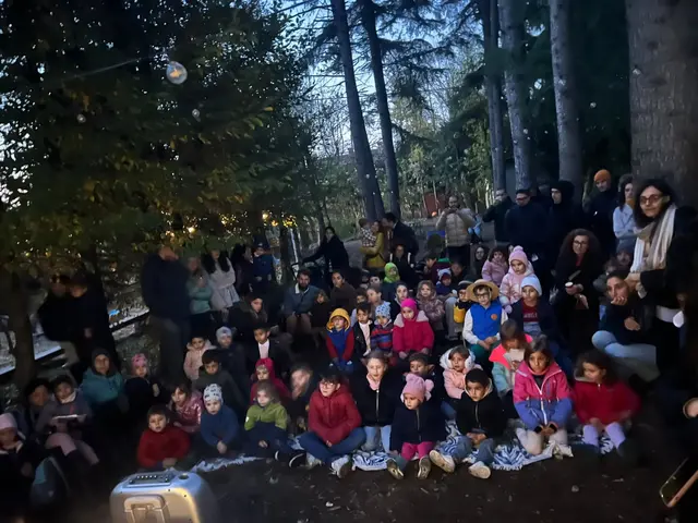 Il pubblico della lettura animata dello scorso anno: bambini e genitori seduti davanti al palco, all'imbrunire