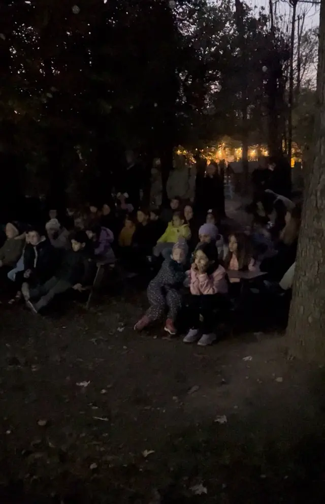 Bambini e genitori riuniti nel bosco al buio, alla Lanternata dello scorso anno
