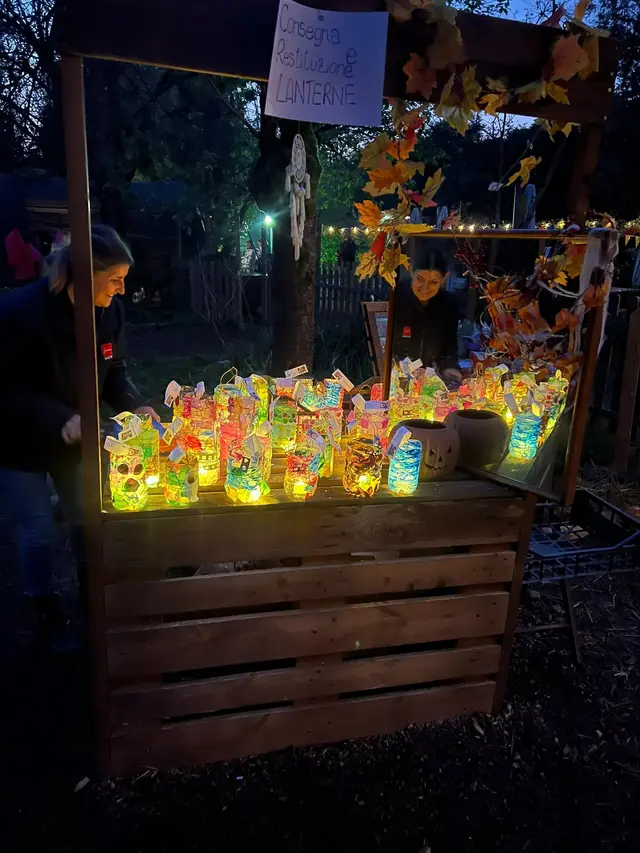 Il banco di legno con le lanterne decorate dai bambini, già accese, mentre scende il buio
